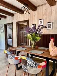 a dining room with a wooden table with a vase of flowers at Bieszczadzki Hoży Ryś Apartamenty in Berezka