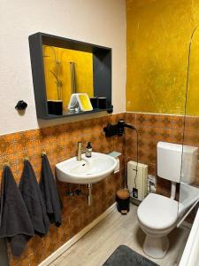 a bathroom with a sink and a toilet and a mirror at Moderne Retro Perle am Niederrhein in Alpen