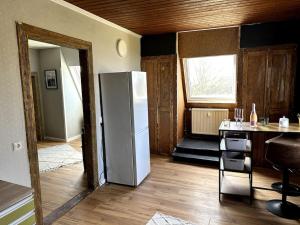 a kitchen with a refrigerator in the middle of a room at Moderne Retro Perle am Niederrhein in Alpen