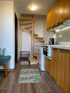 a kitchen with wooden cabinets and a spiral staircase at To Patriko Mas Guesthouse-2 in Palaios Panteleimonas