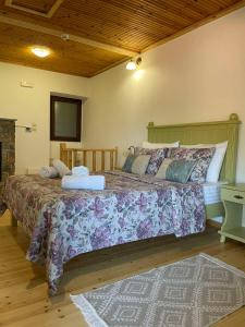 a bedroom with a large bed with a purple blanket at To Patriko Mas Guesthouse-2 in Palaios Panteleimonas