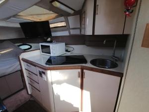 a small kitchen with a microwave and a sink in a caravan at Dormir sur un yacht insolite in La Rochelle