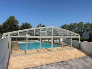 a glass house with a swimming pool on a roof at Chalet Eguzkitsua 3 étoiles avec piscine et barbecue - pays basque - in Hasparren