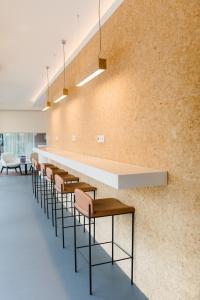 a row of chairs and tables in a room with a wall at Canadiano Urban Nature Hotel in Ponta Delgada