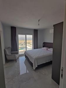 1 dormitorio con 1 cama, 1 silla y 1 ventana en Serene 3-Bed Villa with Pool, Stunning Views & Beach Access in Dalaman, en Dalaman