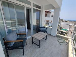 sala de estar con mesa y sillas en el balcón en Serene 3-Bed Villa with Pool, Stunning Views & Beach Access in Dalaman, en Dalaman