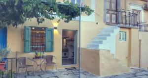 een huis met een tafel en stoelen en een trap bij ALEMINAS HOUSE in Symi