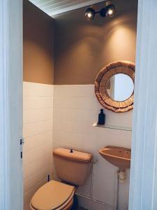 a bathroom with a toilet and a sink and a mirror at La Villa Didine in Sainte-Luce