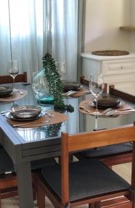 una mesa de comedor con copas de vino y una planta en La Villa Didine, en Sainte-Luce