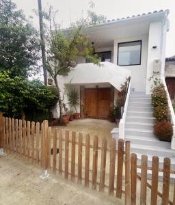 une maison blanche avec une clôture et un portail dans l'établissement Casa Caliza, à Puertas