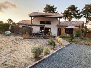 Casa pequeña con mesa y patio en Charmante villa avec studio indépendant en Vendays-Montalivet