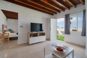 a living room with a flat screen tv and a couch at Santa Rosa La Peñita (Puerto del Carmen) in Puerto del Carmen