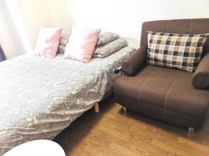 1 cama, 1 sofá y 1 silla en una habitación en DP House, en Tokio