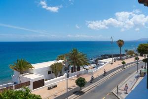 a view of a street with the ocean in the background at Santa Rosa La Peñita (Puerto del Carmen) in Puerto del Carmen