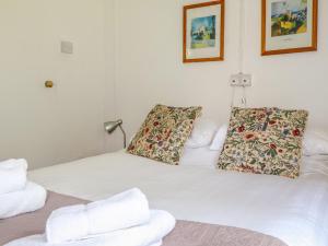 białe łóżko z dwoma poduszkami w obiekcie Can Yr Afon w mieście Caernarfon