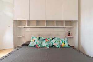 1 dormitorio con 1 cama con almohadas y armarios blancos en La casa sull'albero Navigli en Milán