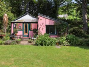 uma pequena casa rosa num quintal em Can Yr Afon em Caernarfon