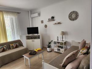 een woonkamer met een bank en een tafel bij Queen Aspri apartment 3' min to the beach! in Antikyra