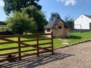 a wooden fence in front of a small house at Central Scotland Country Side With Outdoor Bbq Hut in Strathaven