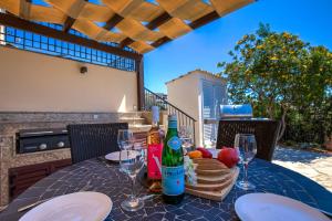 un tavolo con bottiglie di vino, pane e bicchieri da vino di 3 bedroom Villa Melandra with private pool and sea views, Aphrodite Hills Resort a Kouklia