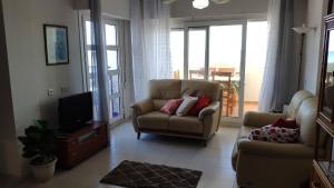een woonkamer met een bank en een tv bij 2 Bedroom Apartment Front Line Of The Beach in Roquetas de Mar