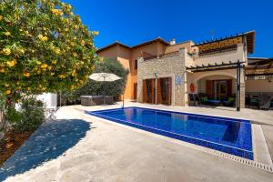 una villa con piscina di fronte a una casa di 3 bedroom Villa Melandra with private pool and sea views, Aphrodite Hills Resort a Kouklia