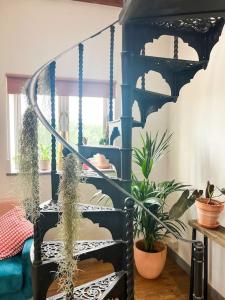 a blue spiral staircase in a room with potted plants at Aplanty Nest amidst the Orchard 