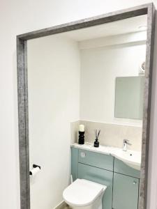 a bathroom with a white toilet and a sink at Aplanty Nest amidst the Orchard 