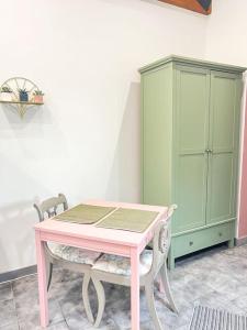 a pink table and two chairs and a green cabinet at Aplanty Nest amidst the Orchard 