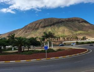 a road in front of a mountain with palm trees at Room in Lodge - Big Room Tenerife Sur Private Bathroom Wifi in Arona