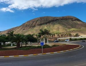a road in front of a mountain with palm trees at Big Room Tenerife Sur Private Bathroom Wifi in Arona