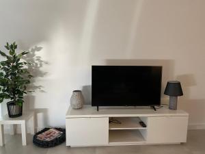 TV en un centro de entretenimiento blanco en una sala de estar en Villa Demi-Adore, en Mazarrón