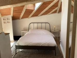 ein Schlafzimmer mit einem Bett in einem Zimmer mit Holzdecken in der Unterkunft NOCNOC - L'Artiste du Capitole, hyper-centre, 4 lits in Toulouse