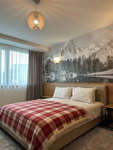 a bedroom with a bed with a plaid blanket at Penthouse Poiana Brașov B44 in Poiana Brasov