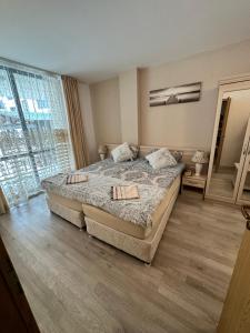 ein Schlafzimmer mit zwei Betten und einem großen Fenster in der Unterkunft AVALON, Apartment C102 in Sonnenstrand + 33 Fotos