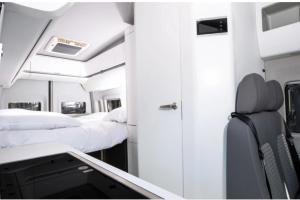 Habitación con 2 camas y escritorio. en Campervan Rental Dublin - VW Grand California, en Dublín