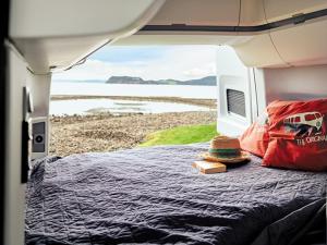 a bedroom with a bed with a view of the ocean at Campervan Rental Dublin - VW Grand California in Dublin