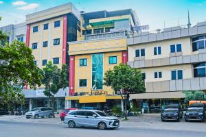 un groupe de voitures garées devant un bâtiment dans l'établissement SUPER OYO Collection O 92690 Hotel Limas, à Palembang