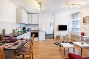 eine Küche und ein Wohnzimmer mit einem Tisch und Stühlen in der Unterkunft Ferienwohnung Am Bach in Rheinfelden