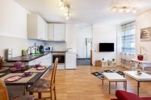 Il comprend une cuisine et un salon avec une table et des chaises. dans l'établissement Ferienwohnung Am Bach, à Rheinfelden