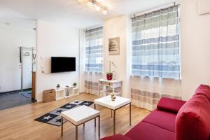 sala de estar con sofá rojo y TV en Ferienwohnung Am Bach en Rheinfelden