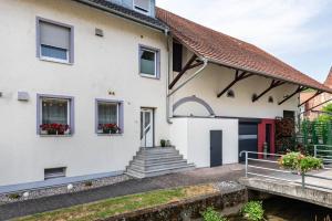 einen Blick auf ein weißes Haus mit einer roten Tür in der Unterkunft Ferienwohnung Am Bach in Rheinfelden