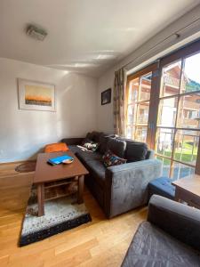 uma sala de estar com um sofá e uma mesa em Daniela 3 by SMR Rauris Apartments - inc Spa and National Summercard - near Gondola em Rauris