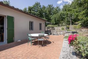 a patio with a table and chairs next to a house at Il Casale in Pistoia