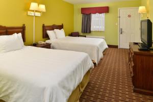 um quarto de hotel com duas camas e uma televisão de ecrã plano em American Inn Princeton em Princeton