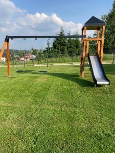 an empty playground with a slide in the grass at WILLA ANNA - 20 procent Termy Gorący Potok in Szaflary