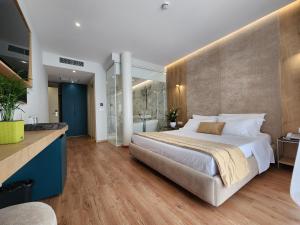 a bedroom with a large bed and a bathroom at Hotel Gold in Vlorë