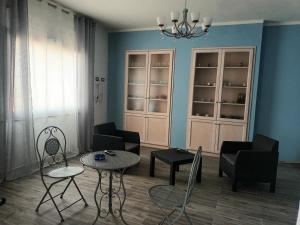 uma sala de estar com cadeiras e mesas e um lustre em Valentina's garden house em Triei