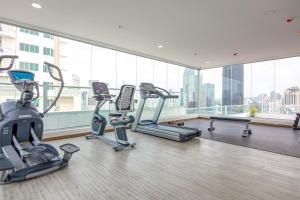 a gym with cardio equipment in a large room with a large window at Boutique Apartments Panamá Marbella in Loma del Naranjo