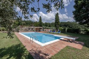 a swimming pool in a yard with two chairs around it at Il Casale in Pistoia